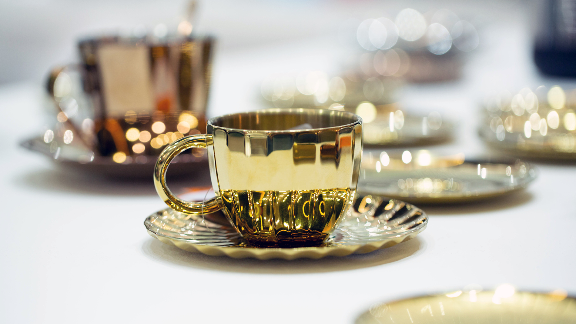 Global Sourcing Dining Table: Tassen mit Untertassen in Gold auf der Ambiente