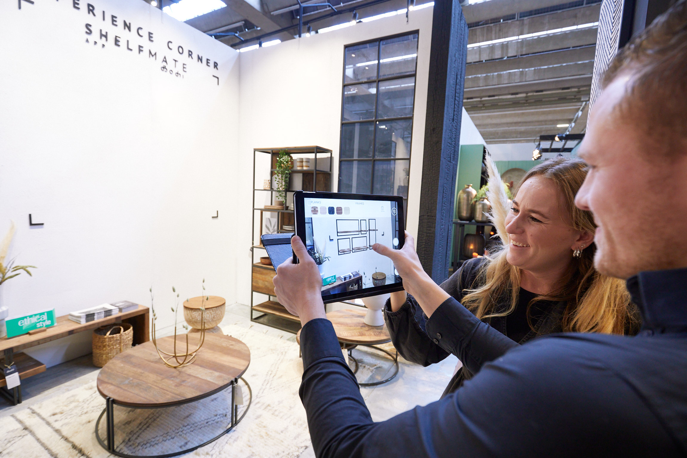 Frau und Mann am Tablet vor einem Messestand