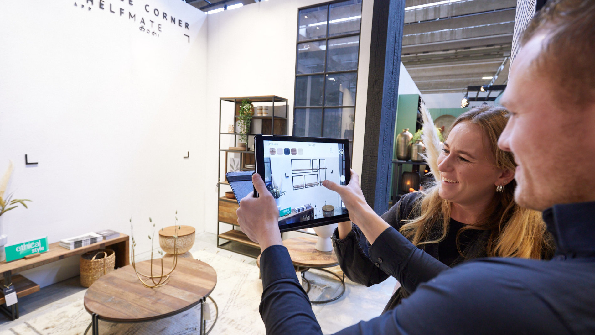 Frau und Mann am Tablet vor einem Messestand